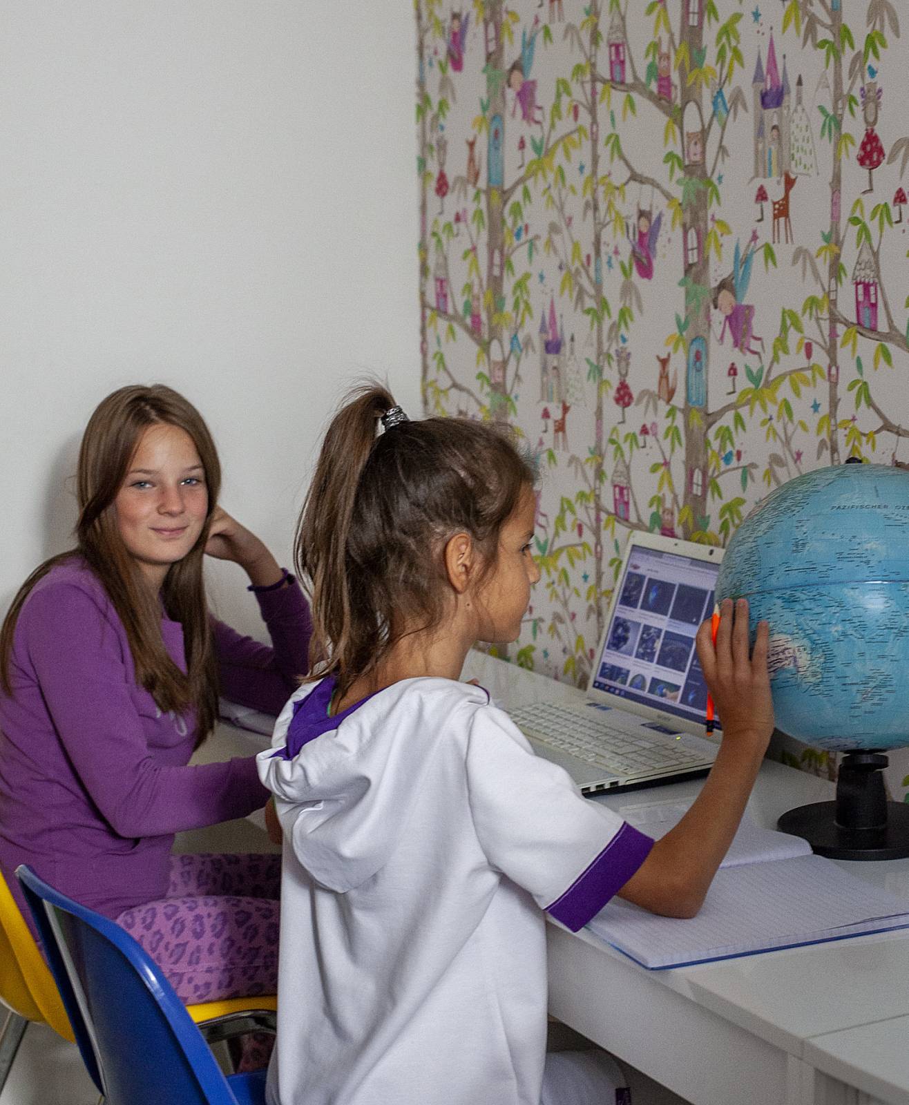 djevojčice u učionici drže globus